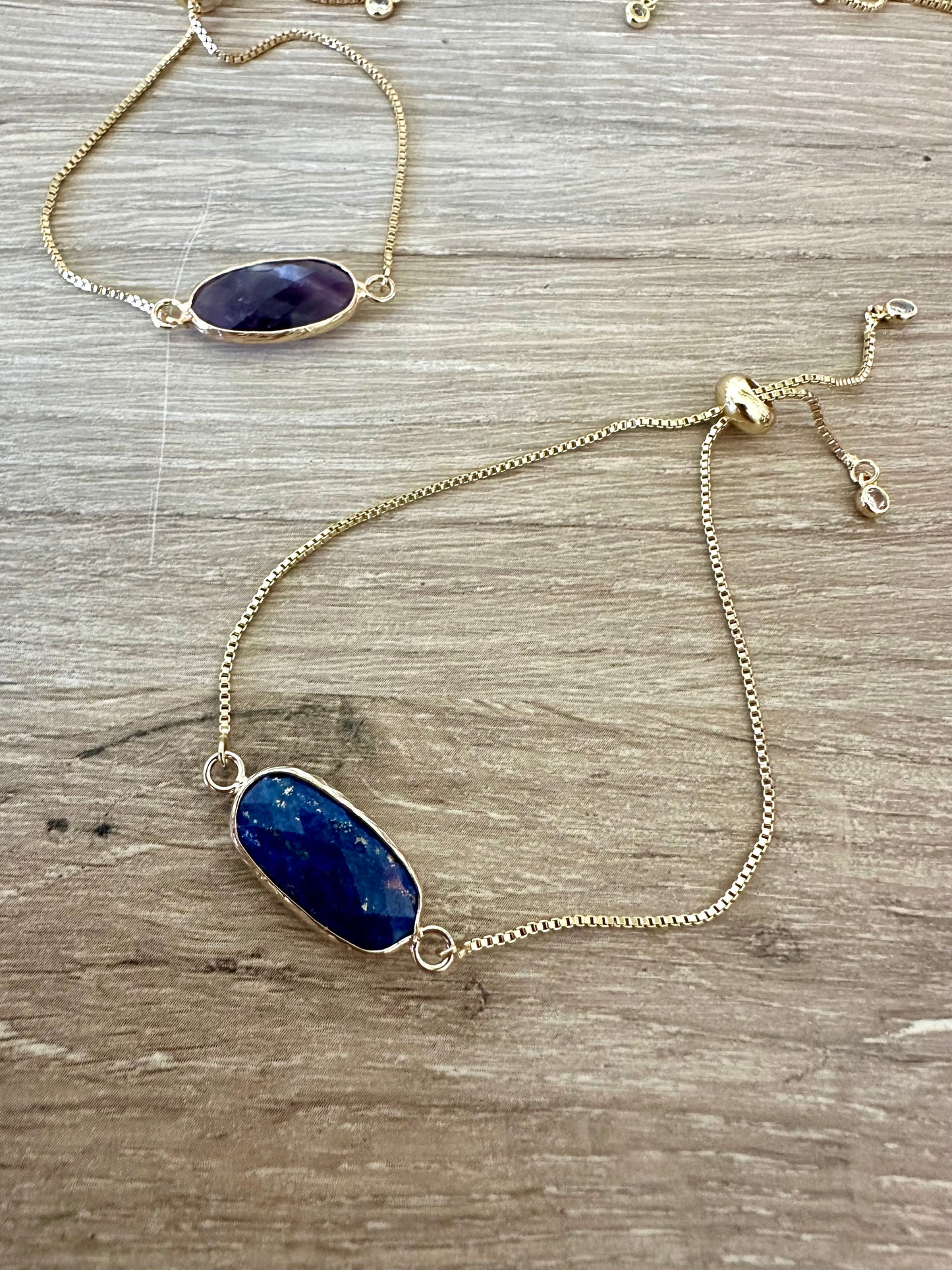 Gold bracelet with blue stone on a wooden surface