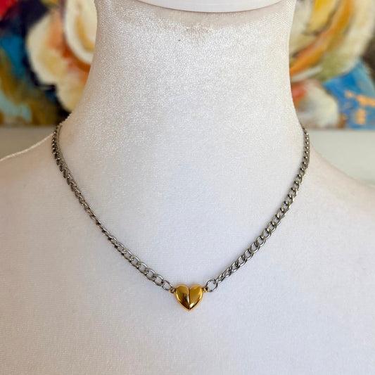 Necklace with a heart-shaped pendant on a mannequin against a colorful abstract background