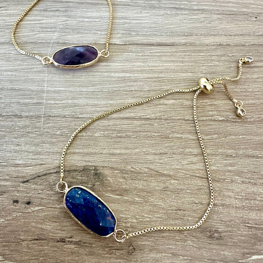 Gold bracelet with blue stone on a wooden surface