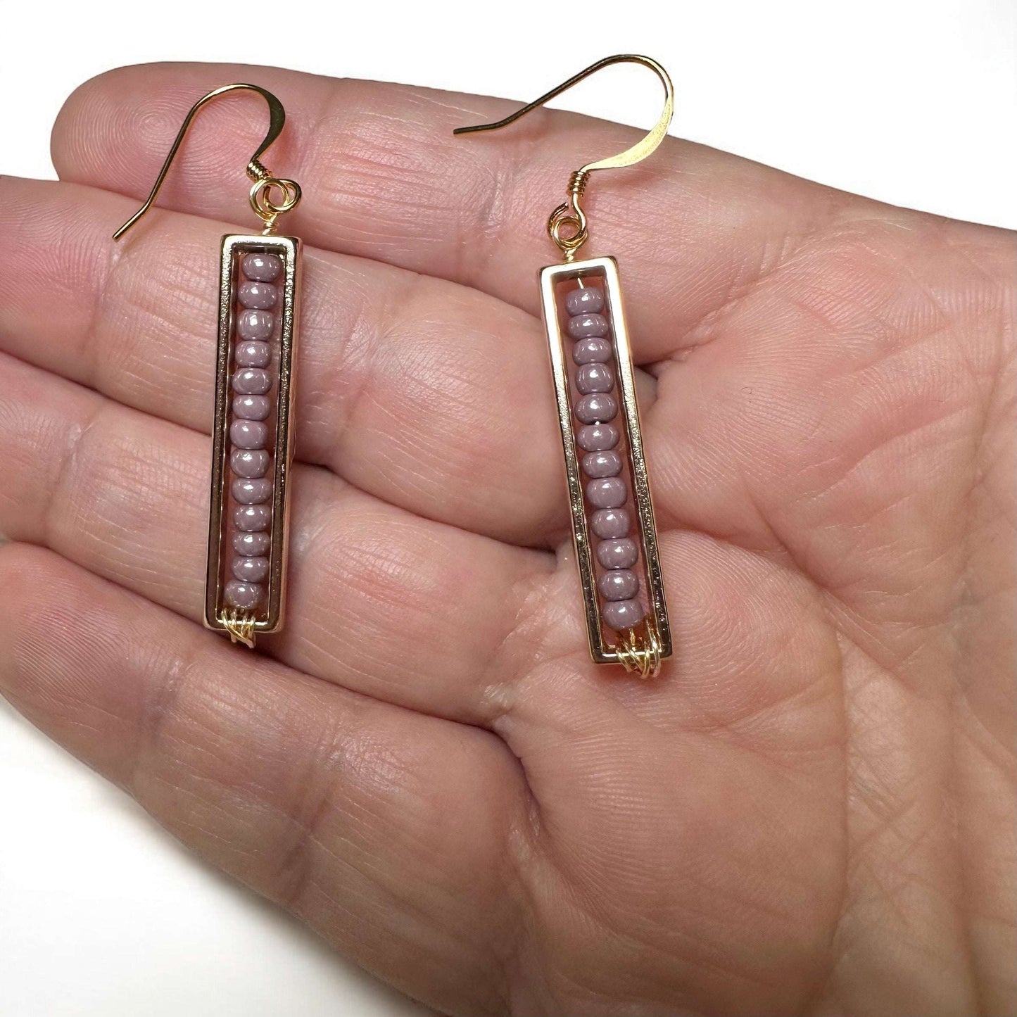 Spectrum strips beaded earrings gold plated ear wire lavender color in hand for scale