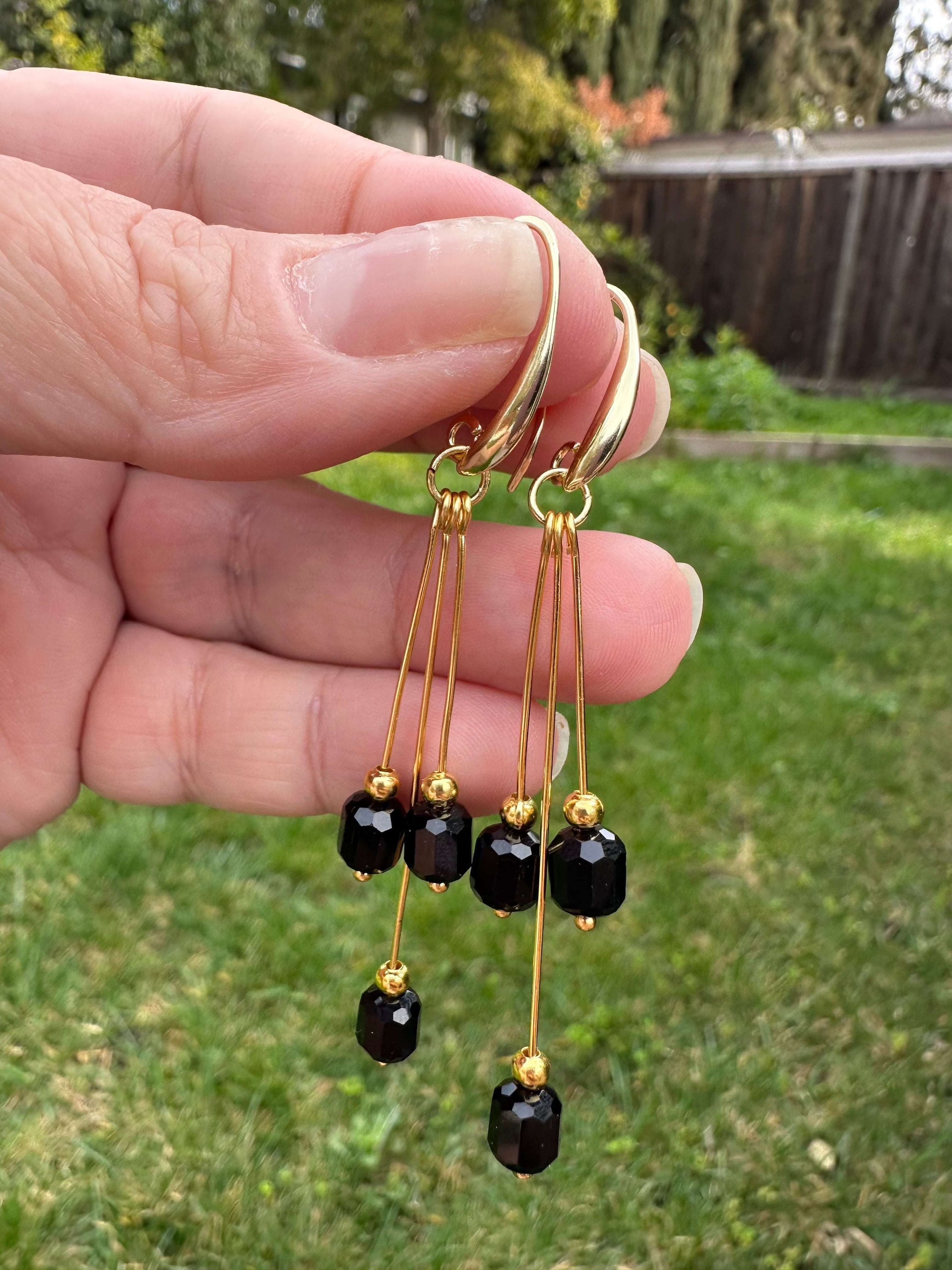 Pure Elegance Earrings - Gold Filled with crystals hanging from fingers