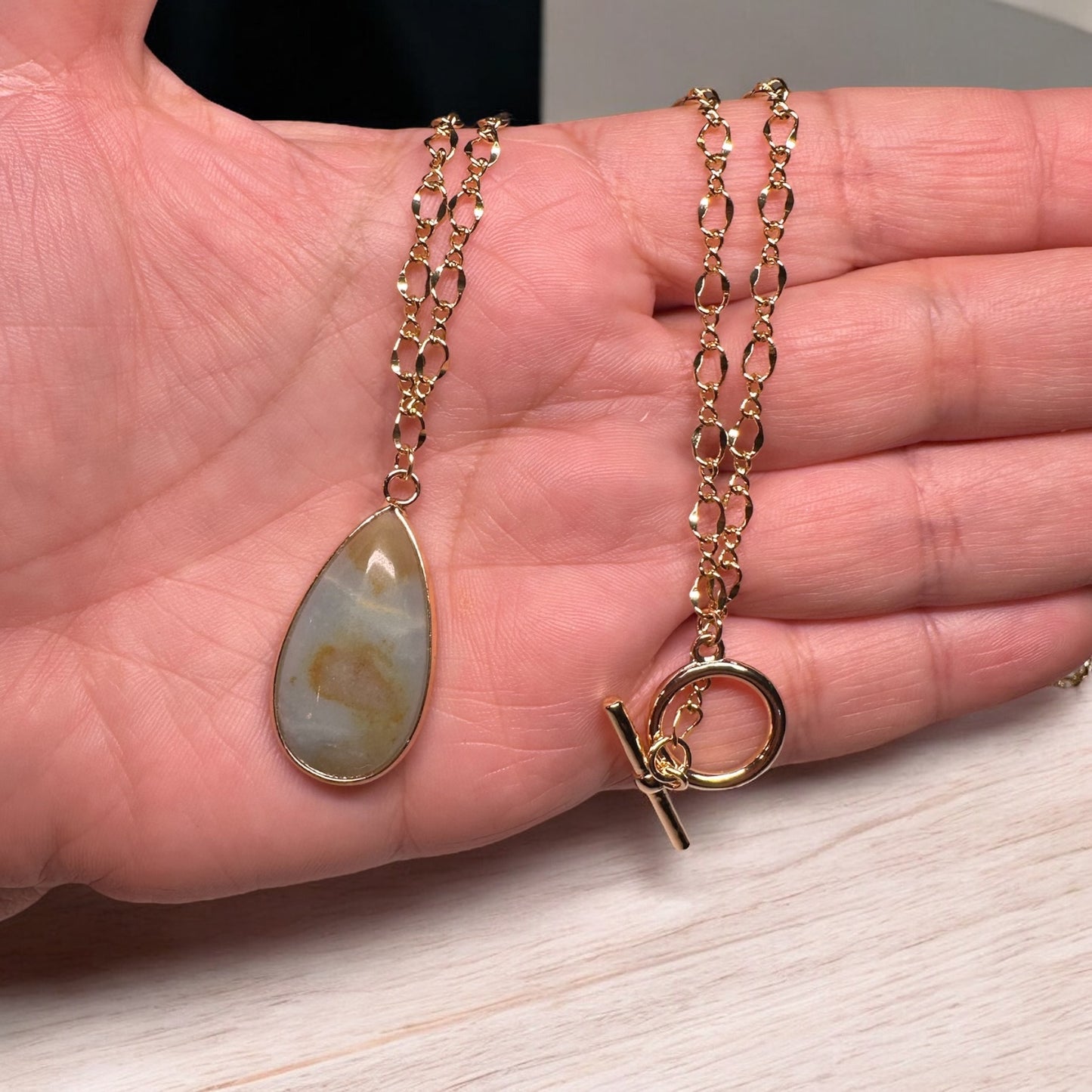 Gold filled 18" necklace with teardrop shaped Amazonite pendant in hand for scale