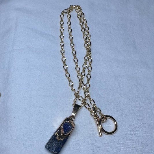 18" Gold filled necklace with Lapis pendant on table.